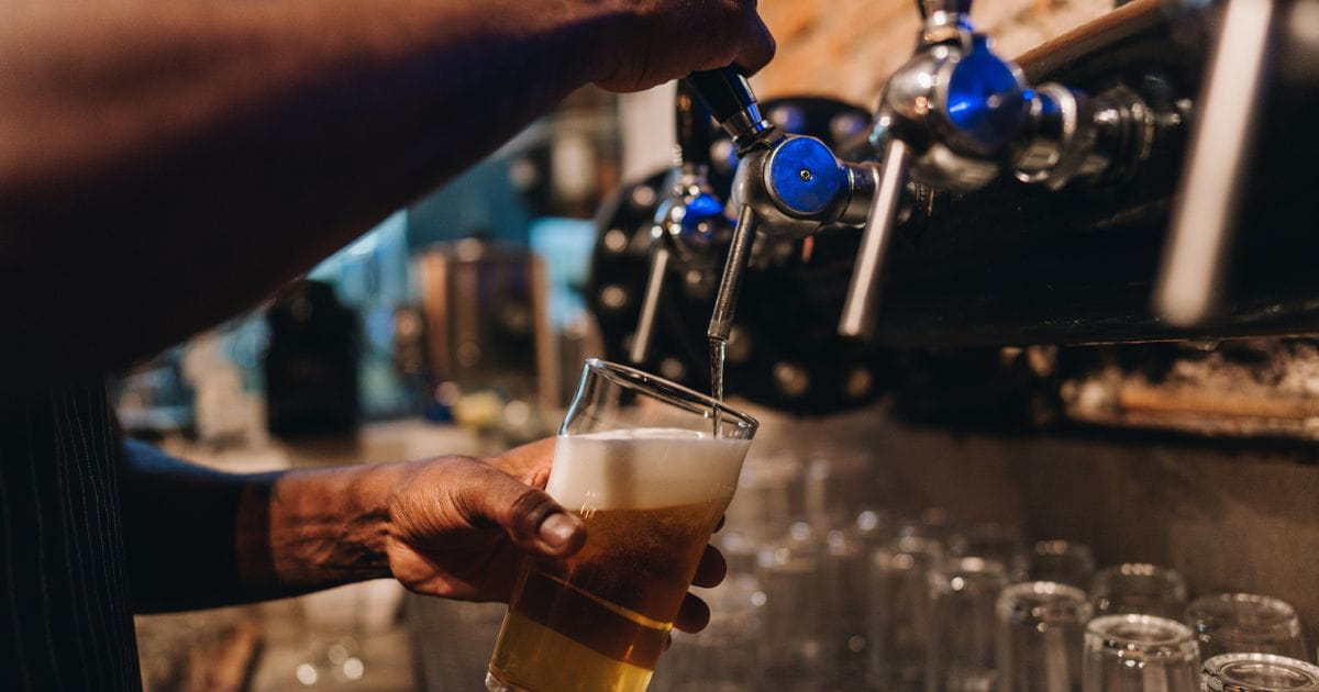 A person pulling a pint in a pub