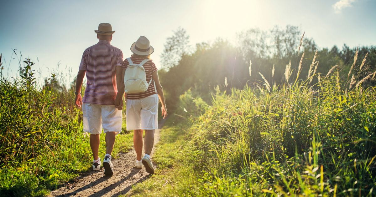 A stock image of a couple walking through a meadow