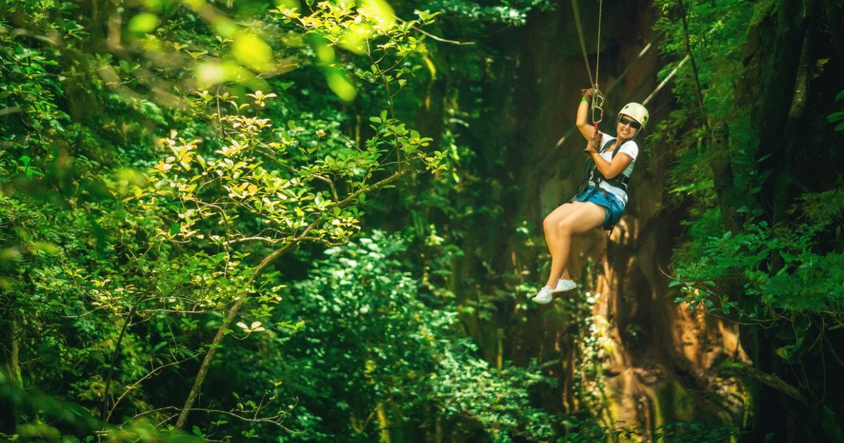 A woman ziplining as part of a treetop adventure activitiy