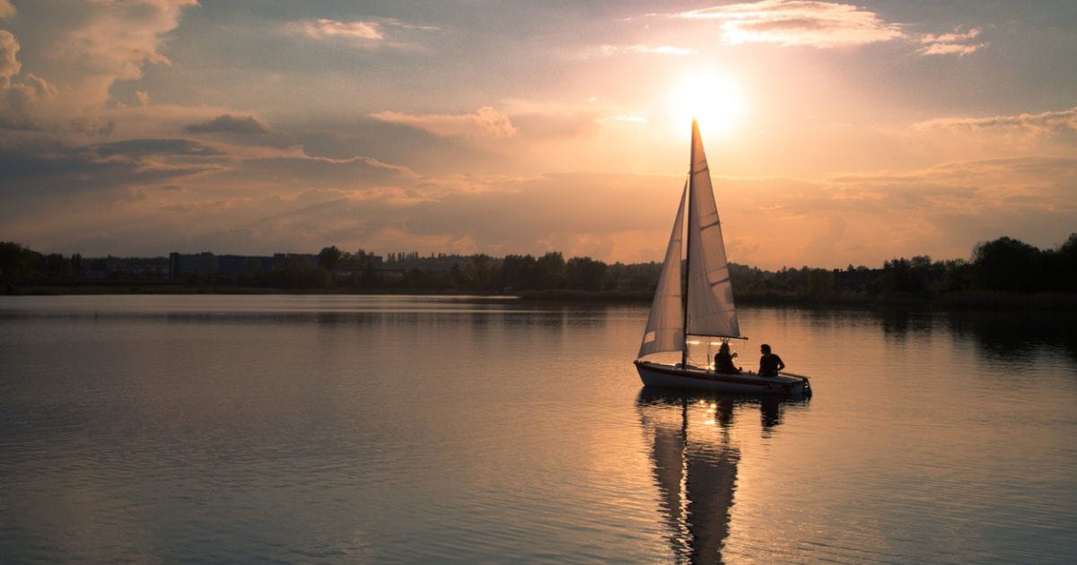 A sailboat on a lake at sunset