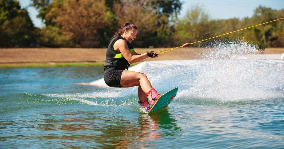 A woman smiling while wakeboarding