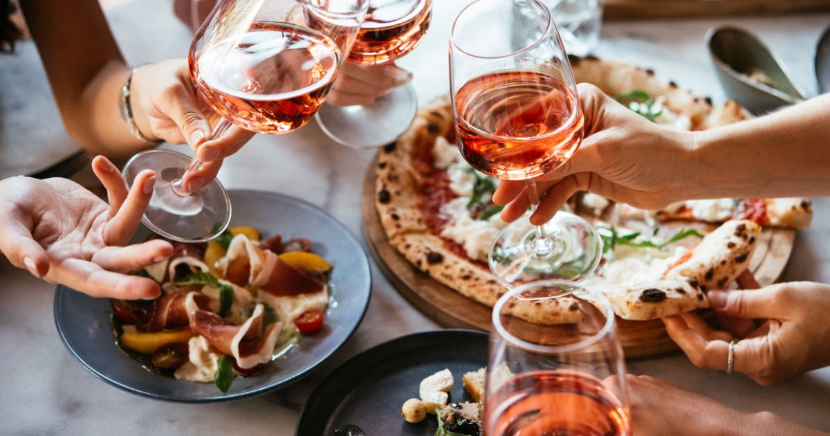 People cheersing drinks over italian food restaurant stock photo