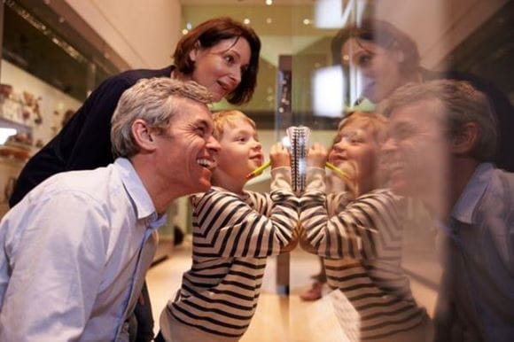 A family with a man, woman and child smiling in a museum